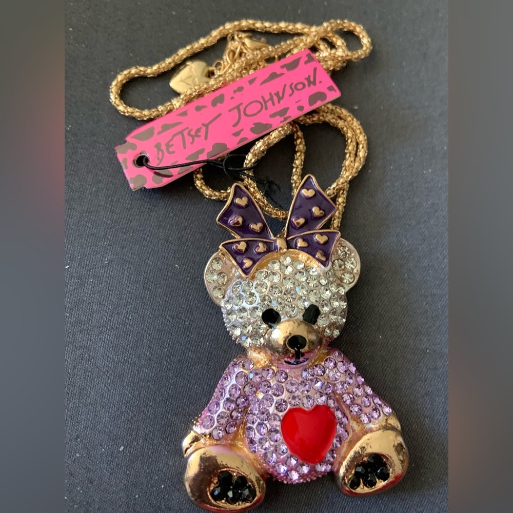 BJ girl teddy bear with lavender dress and dark purple between ears.